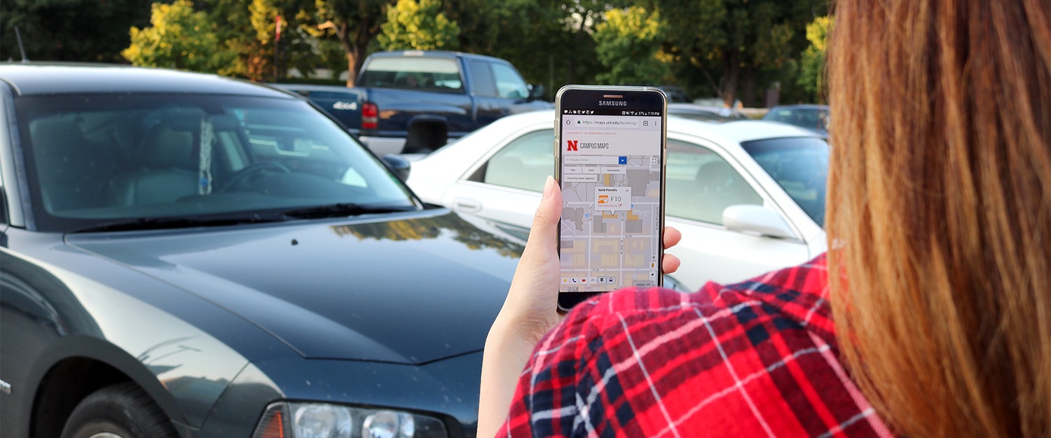 Lady looking for parking lot using Campus Maps app on smart phone